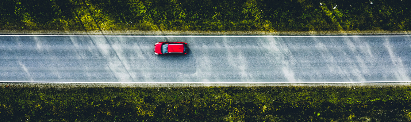 Car, driving down an open road lined with trees.