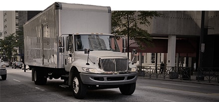 Commercial truck driving down a small street