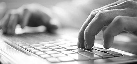 Hands typing on keyboard photo in black and white