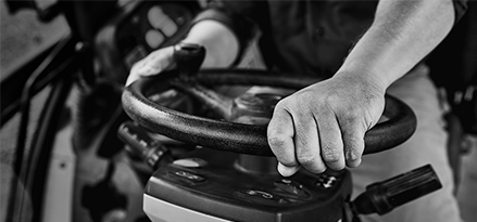 Photo en noir et blanc de mains sur un volant